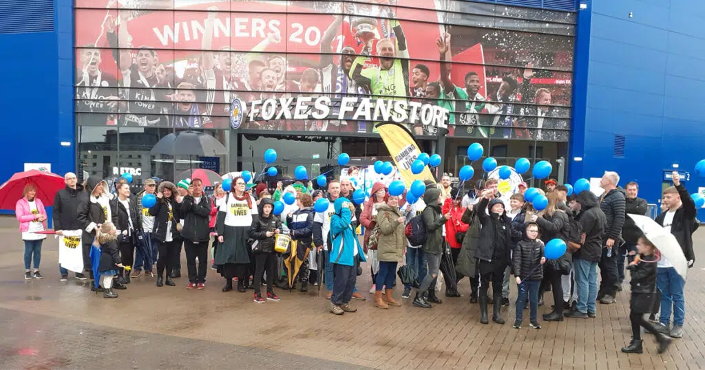 Collection of people with blue ballons outside Leicester City FC's home ground to celebrate what would've been Luke Ashton's 41st birthday